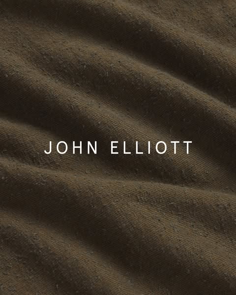 This ad showcases the John Elliott brand by displaying a close-up of a textured fabric, emphasizing the brand's name