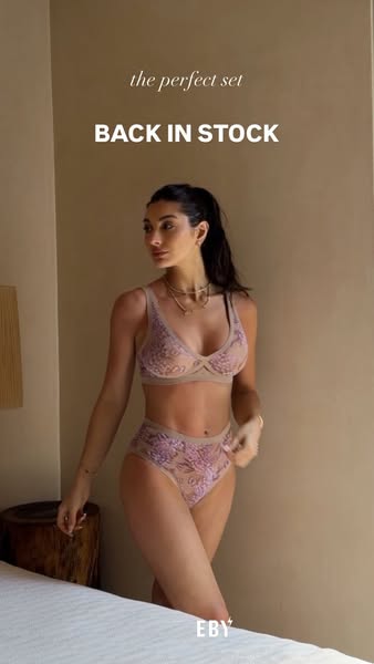 This image ad for EBY features a model wearing a matching bra and panty set in a neutral color with a floral pattern. Te