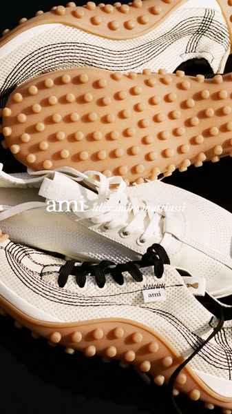 The image ad showcases three AMI Alexandre Mattiussi sneakers stacked on top of each other. The focus of the image is on