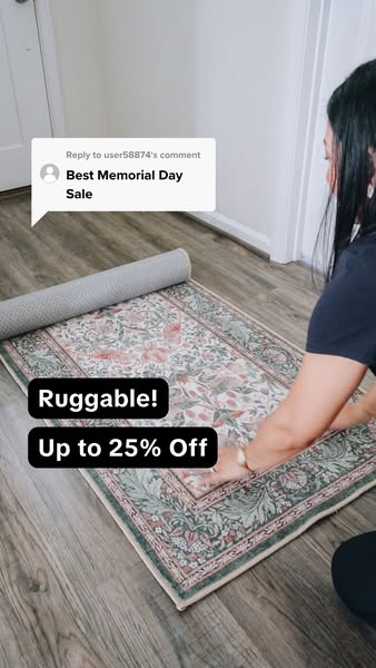 This ad shows a patterned Ruggable rug being unrolled on a wood floor. Text overlays advertise a Memorial Day sale, offe