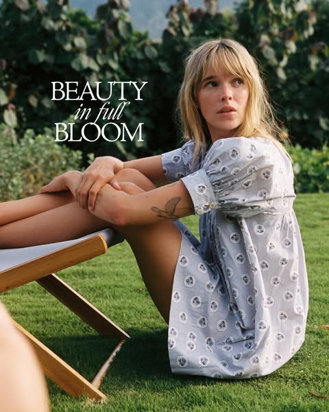 This image ad features a woman in a dress sitting outside on the grass. The ad promotes beauty in simplicity and showcas