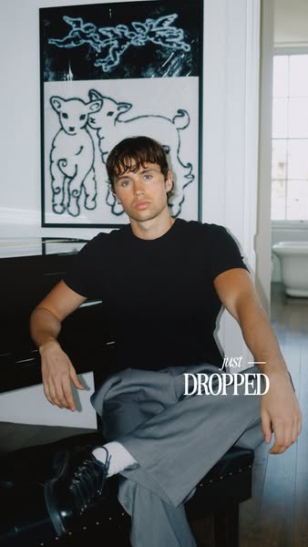 A product ad that showcases a new clothing drop by featuring a creator sitting on a piano in a room that looks like it m