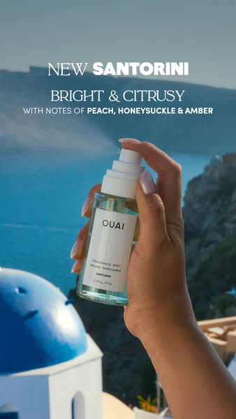 This image ad promotes OUAI's new Santorini fragrance mist. It features a person holding and spraying the product ag