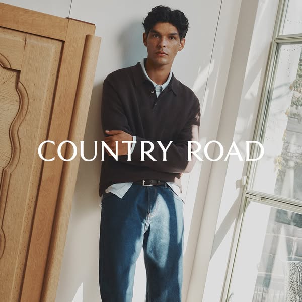 This ad features a man wearing Country Road clothing in a casual indoor setting.
