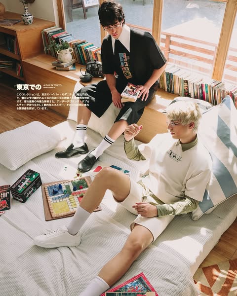 This ad showcases two young Asian men in a casual indoor setting, wearing clothing that appears to be from a new collect