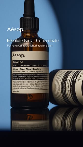 This image ad features two Aesop Resolute Facial Concentrate bottles against a blue background. The ad highlights the pr