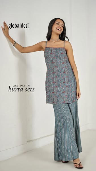 This ad showcases a woman wearing a kurta set from Global Desi. She is standing and leaning against a wall. Text overlay