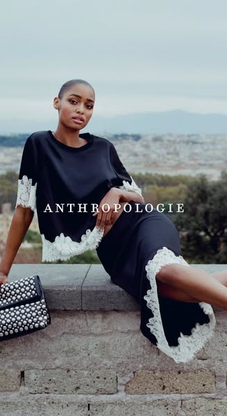 An ad for Anthropologie features a Black woman wearing a matching black top and skirt with white lace trim and a silver 