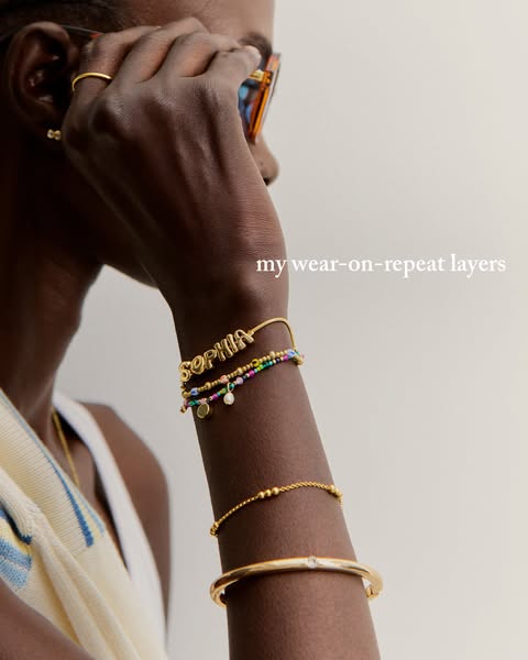 This image ad showcases a person wearing various gold bracelets and other jewelry.