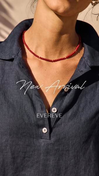 This ad features a close-up shot of a woman wearing a red beaded necklace and a dark blue linen top from Evereve's n