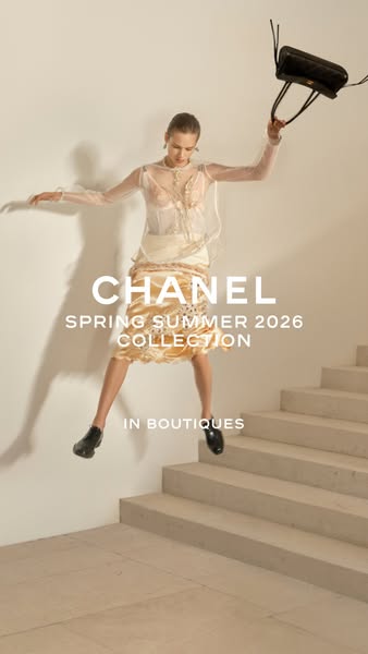 This image ad for Chanel's Spring Summer 2026 Collection features a woman in luxury clothing leaping down a set of s
