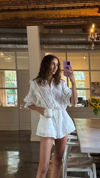 This ad features a woman in a white romper holding a mug. The ad's focus is on the clothing worn by the woman.