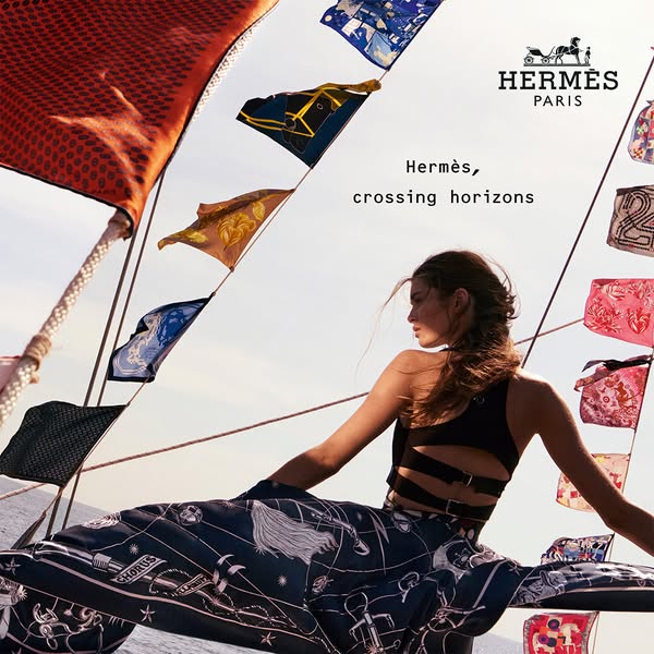 This ad is for Hermès, showcasing a lifestyle of luxury. The ad features a woman on a sailboat with Hermès scarves, conn