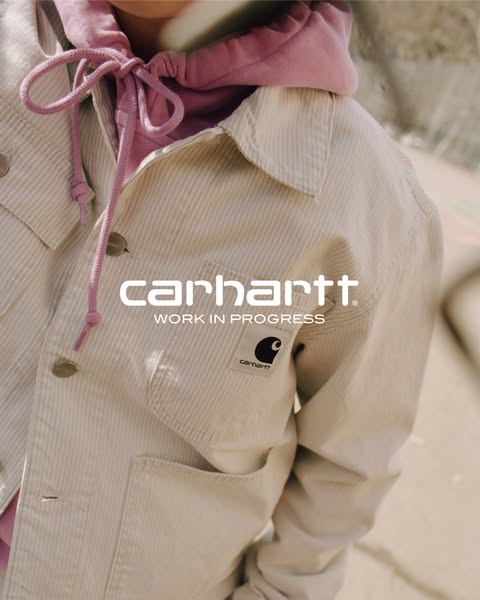This ad is for Carhartt Work In Progress. It features a close-up shot of a sand-colored corduroy jacket with a pink hood