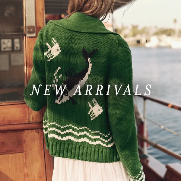 This image ad shows a woman wearing a green sweater with a whale and fish design. It seems to be advertising new arrival
