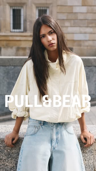 A photo of a fair-skinned woman with long brown hair wearing a beige jacket and light blue jeans. The brand logo 'PU