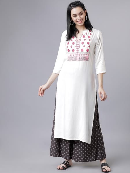 This ad features a woman modeling a white kurta with pink embroidery and dark gray patterned palazzo pants. The ad focus