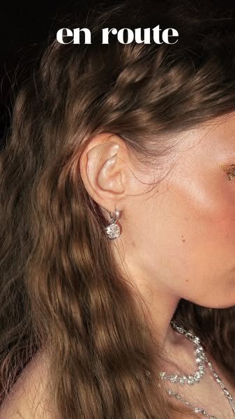 Close up shot of a woman's ear with a diamond earring. The top of the ad includes the brand name. 