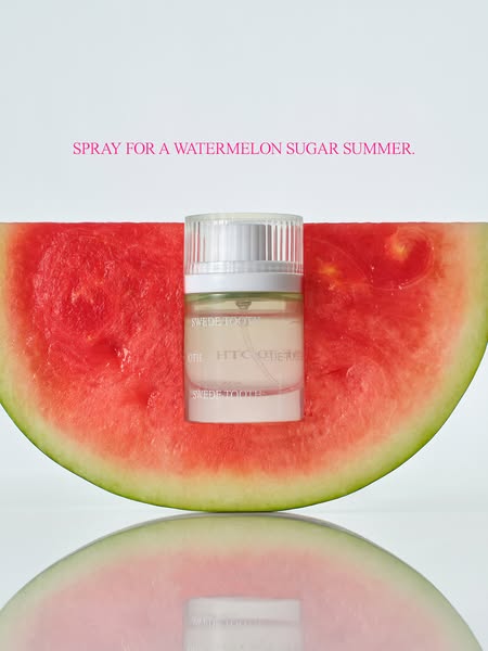 This image ad features a bottle of Swede Tooth perfume positioned in front of a watermelon slice against a white backgro