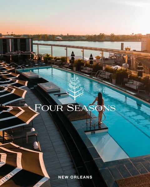 This ad showcases a luxury hotel experience with a woman in swimwear standing at the edge of a rooftop pool overlooking 