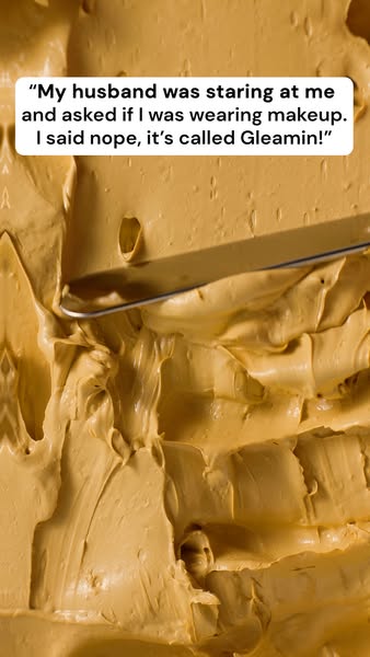 An image ad featuring the product Gleamin'. A quote from a customer is displayed as a person smears a tan-colored cr