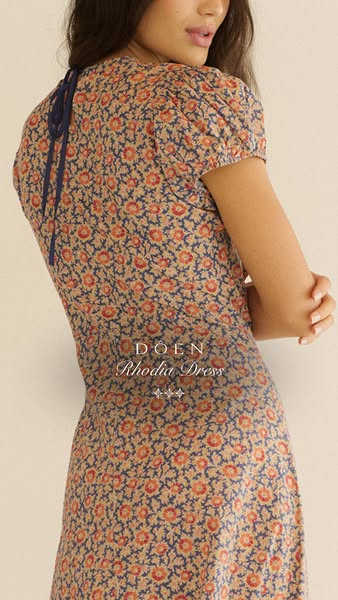 The ad features a woman wearing a floral dress, highlighting the garment's design and style.