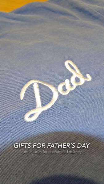 This ad features an up-close shot of a blue shirt with "Dad" embroidered on it in white. The text at the botto