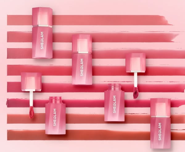 This image ad features SheGlam lip products in multiple shades with a flatlay product shot on a multi-toned background t