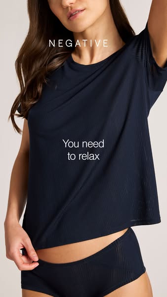 This image ad for Negative Underwear features a model wearing a matching ribbed T-shirt and underwear. The ad promotes t
