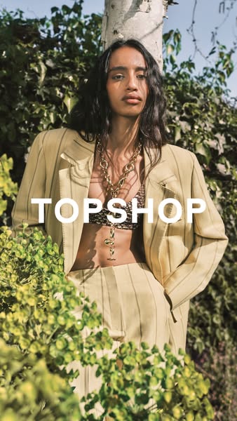 This ad features a model in a yellow and tan striped suit, accessorized with a large necklace. The ad is meant to promot