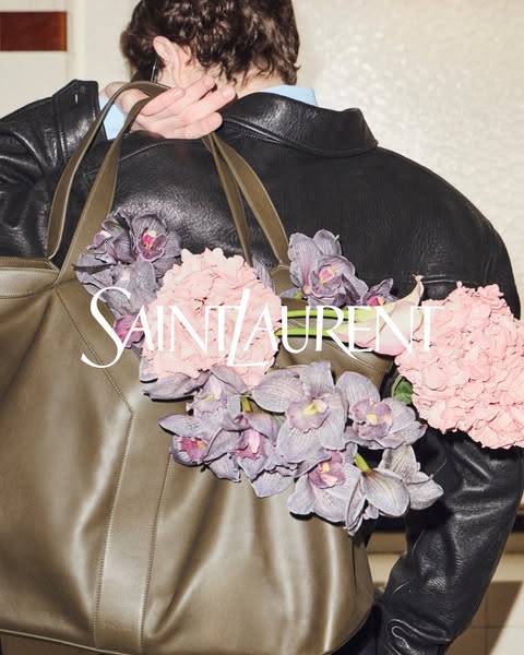 This ad for a Saint Laurent tote bag shows the bag being carried over the shoulder, filled with flowers.