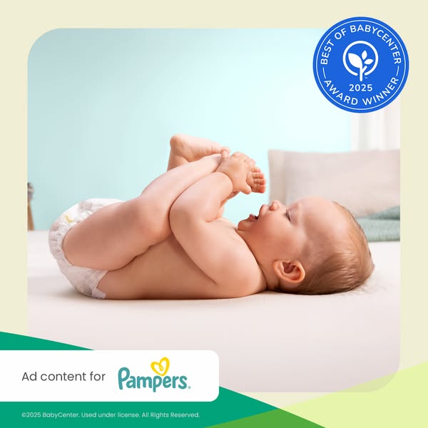 This image ad for Pampers diapers features a baby lying on their back, holding their feet, and an award badge for 'B
