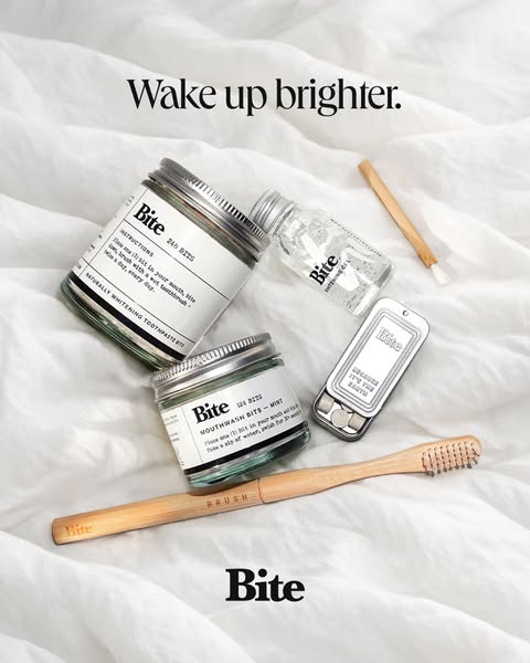 Image ad for Bite, featuring zero-waste toothpaste and mouthwash bits, in a flatlay arrangement on top of white bedding.