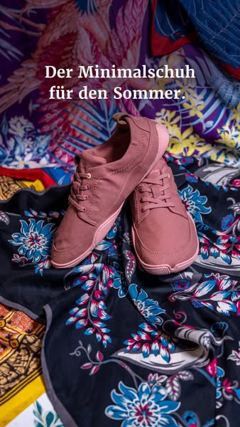 A close-up shot showcases a pair of minimalist shoes positioned on a colorful, patterned cloth, designed for a summer ap
