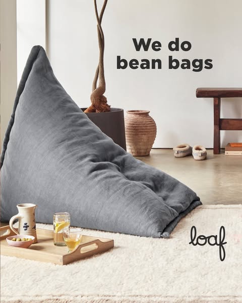 This ad features a large, comfortable-looking bean bag chair in a neutral-toned living space. The headline states, '