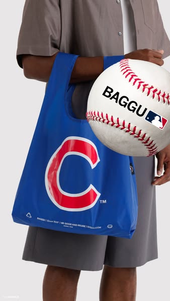This ad features an individual carrying a BAGGU brand reusable shopping bag. The baseball is strategically placed next t