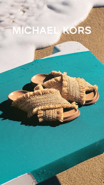 This image ad showcases Michael Kors sandals on a beach, emphasizing the brand's association with a luxurious, relax