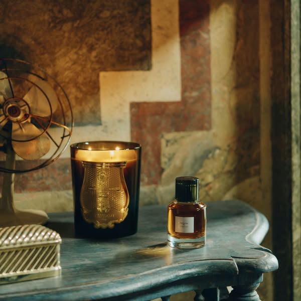 A dimly lit still life showcasing products from Trudon.