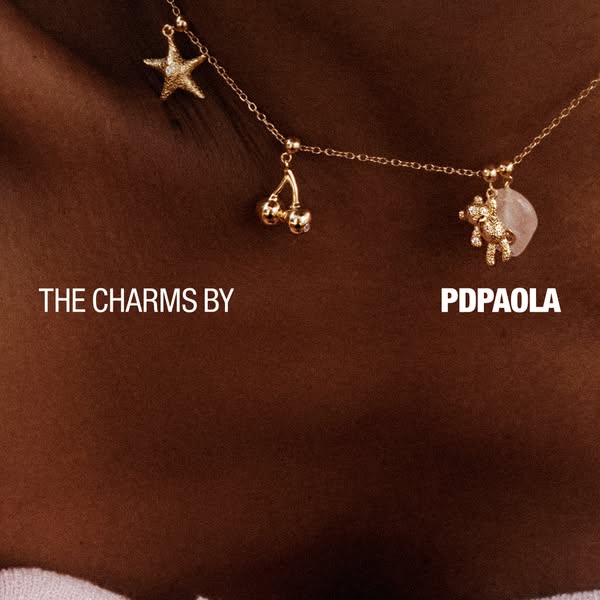 This ad showcases a gold chain necklace with charms from the brand PDPAOLA. The ad focuses on the charms and the brand n
