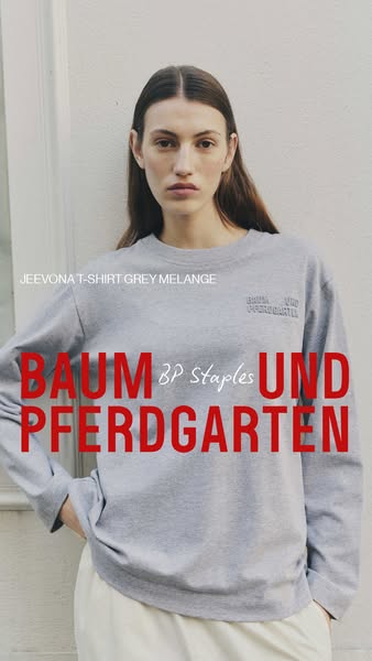 This ad features an image of a woman wearing a Baum Und Pferdgarten t-shirt. The brand name is prominently displayed acr