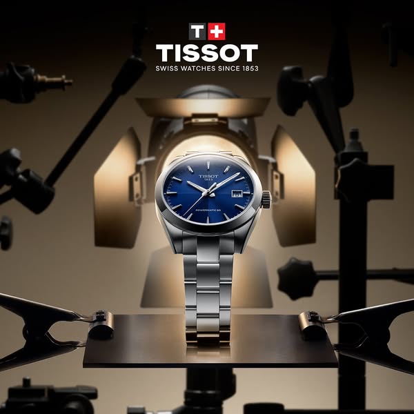 The ad showcases a Tissot watch positioned under studio lighting. The ad emphasizes the brand's history and watch de
