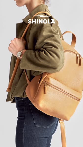 A woman wearing a Shinola backpack and watch. The ad shows the backpack and is branded with the Shinola logo.