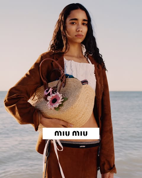 An image ad featuring a model holding a Miu Miu handbag. The brand logo is displayed prominently.