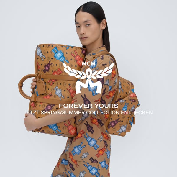 This MCM ad promotes the new Spring/Summer collection, featuring a male model carrying luggage and wearing a matching ou