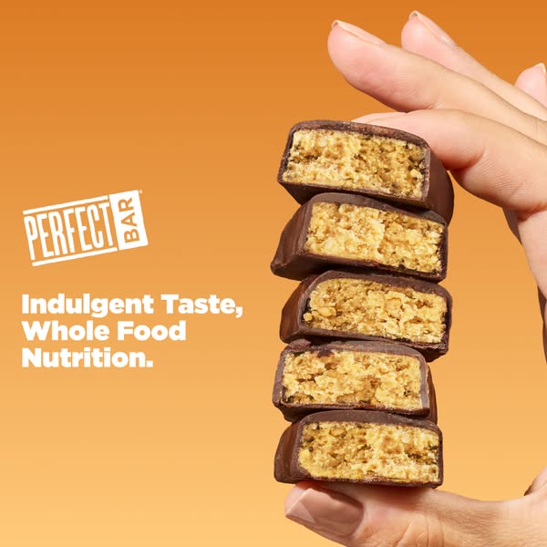 This image ad for Perfect Bar showcases the bar's indulgent taste and whole food nutrition by featuring a hand holdi