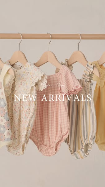This ad showcases a selection of baby clothes, specifically rompers, hung on a wooden clothing rack.
