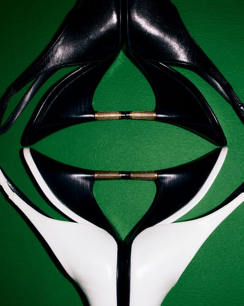 This ad features a vertically mirrored product demo of a pair of heels. One pair of heels is black and the other is whit