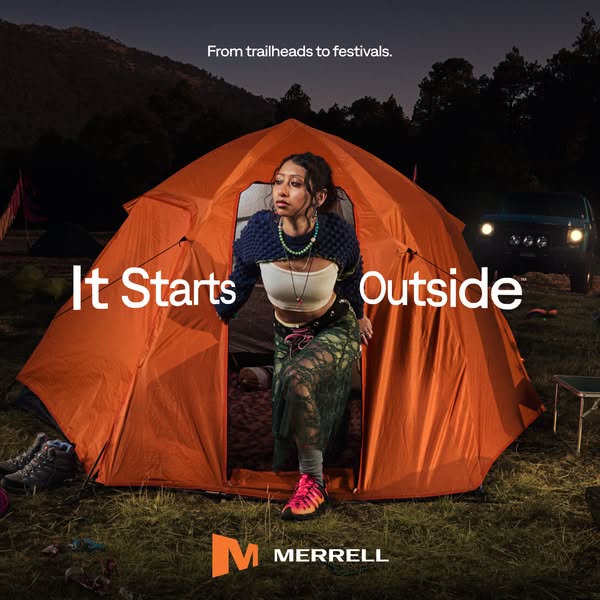 This image ad for Merrell features a person emerging from an orange tent in a wooded setting, juxtaposing outdoor advent