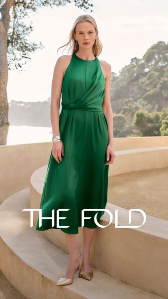 An ad for The Fold features a model wearing a green dress on a beige stone staircase, with a landscape backdrop of trees