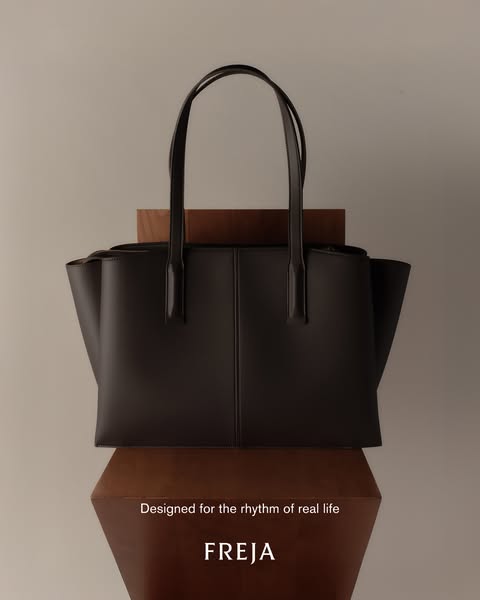 This ad showcases a Freja handbag, emphasizing its design for real-life usability. The simple composition highlights the